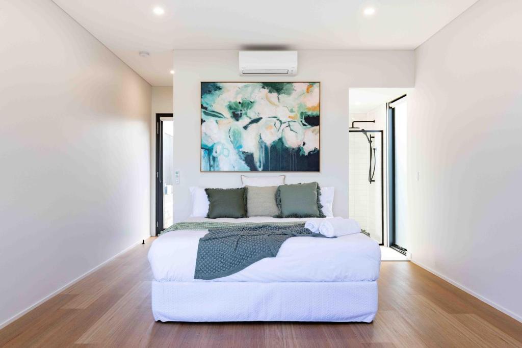 Mount DuneedMt Duneed Estate的卧室配有一张白色大床,墙上挂有绘画作品