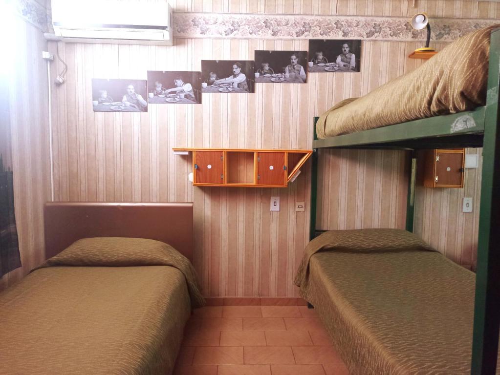 门多萨"C" SPACIO HOSTEL - Habitación Compartida por separado para femenino o masculino-的墙上挂有照片的客房内的两张双层床