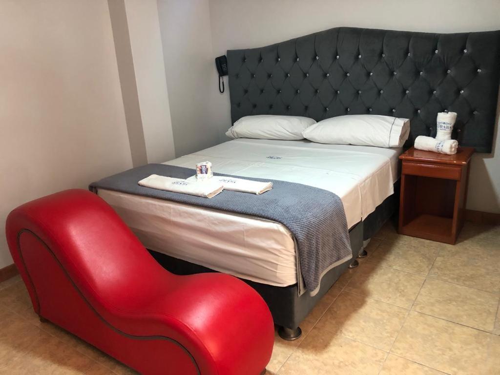 利马Hostal DRABA的一间卧室配有一张床和一张红色椅子