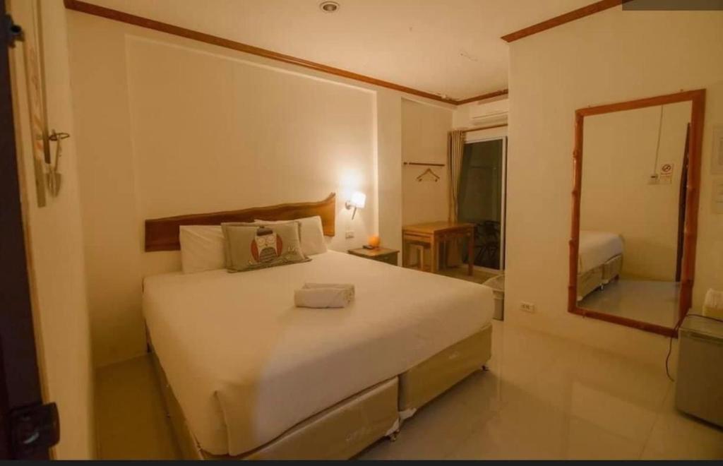 Wang Saphungโรงแรมริเวอร์เลย แกรนด์วิว的卧室配有一张白色大床和镜子