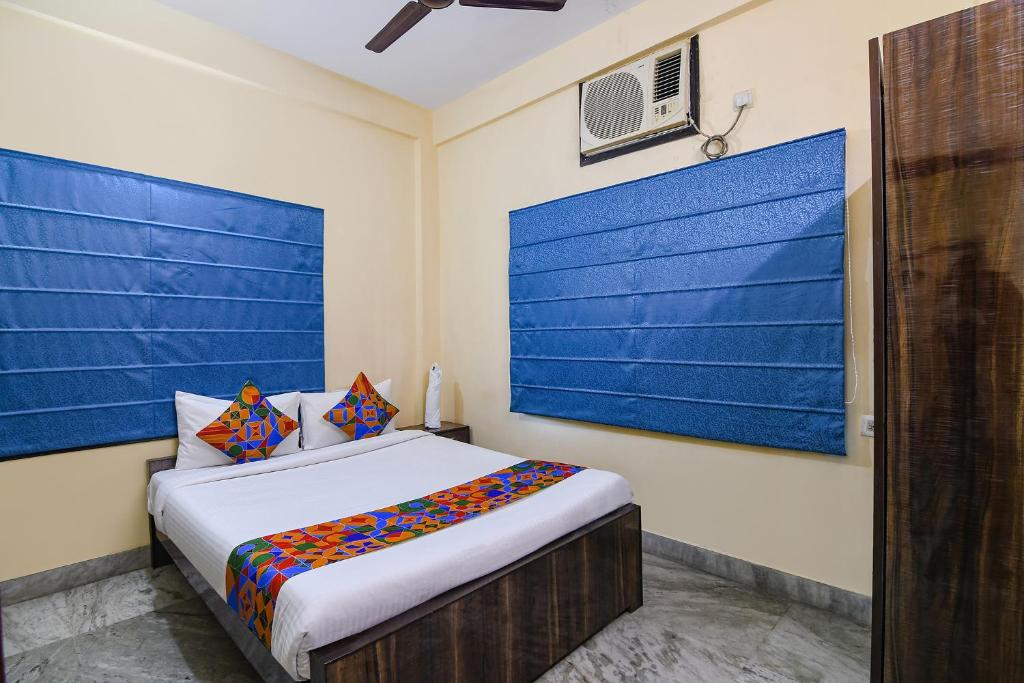 加尔各答FabHotel Sapphire Comfort的一间卧室配有一张蓝色墙壁的床