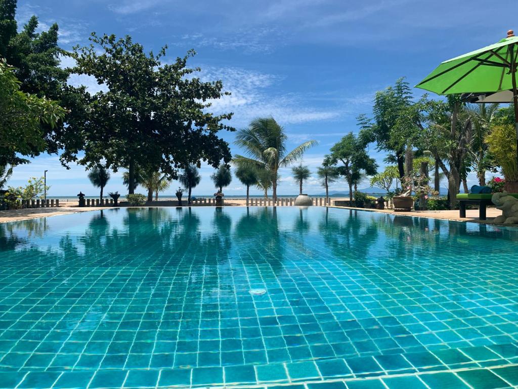 蓝赛特海滩Ban Laem Set - Beachfront Private Luxury Villa的一个带遮阳伞和棕榈树的游泳池