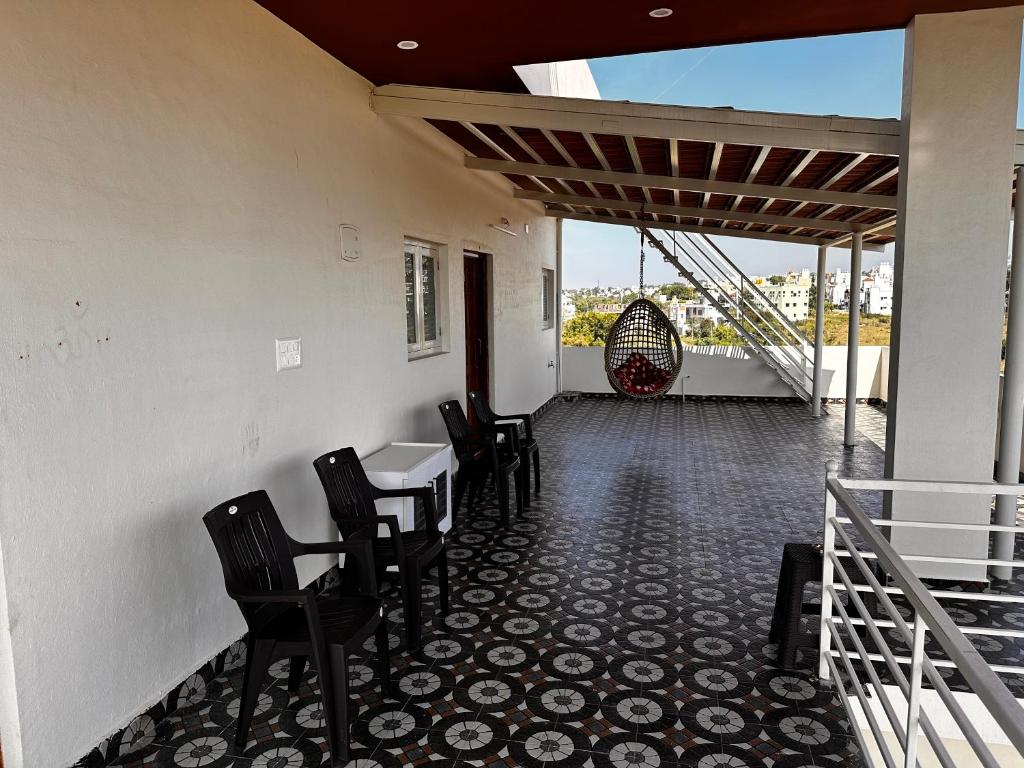 迈索尔DEEYA Guest House的享有美景的带椅子和桌子的用餐室