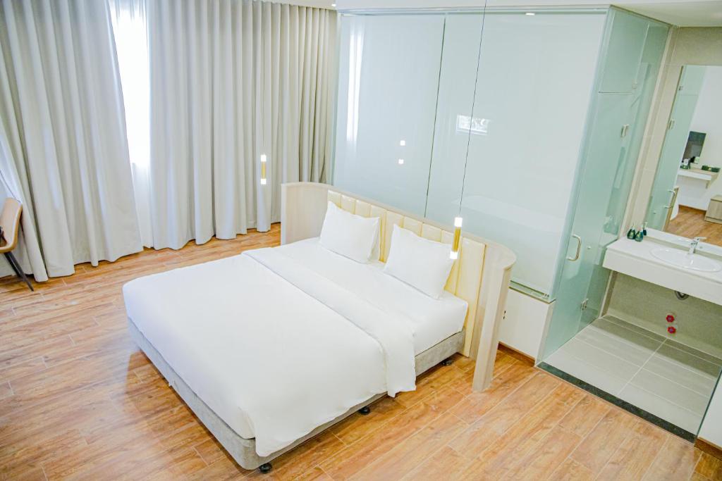 边和The Mansion Hotel Bien Hoa的卧室配有白色的床和镜子