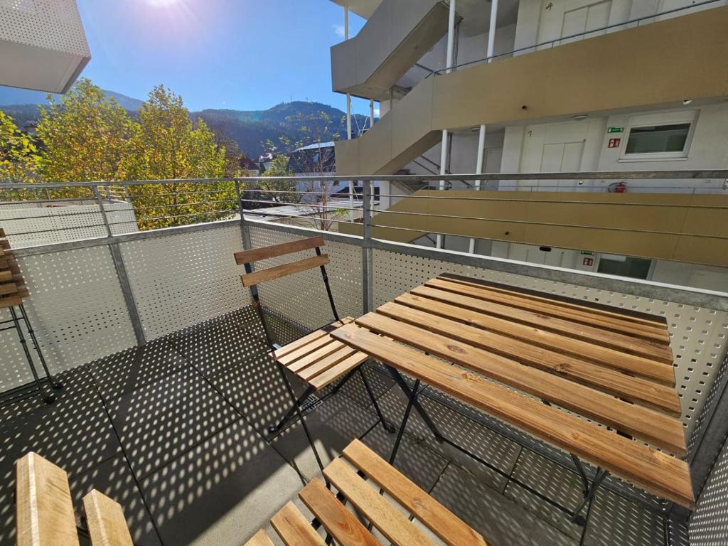 因斯布鲁克Stylish Apartment in Innsbruck + 1 parking spot的阳台顶部的木凳