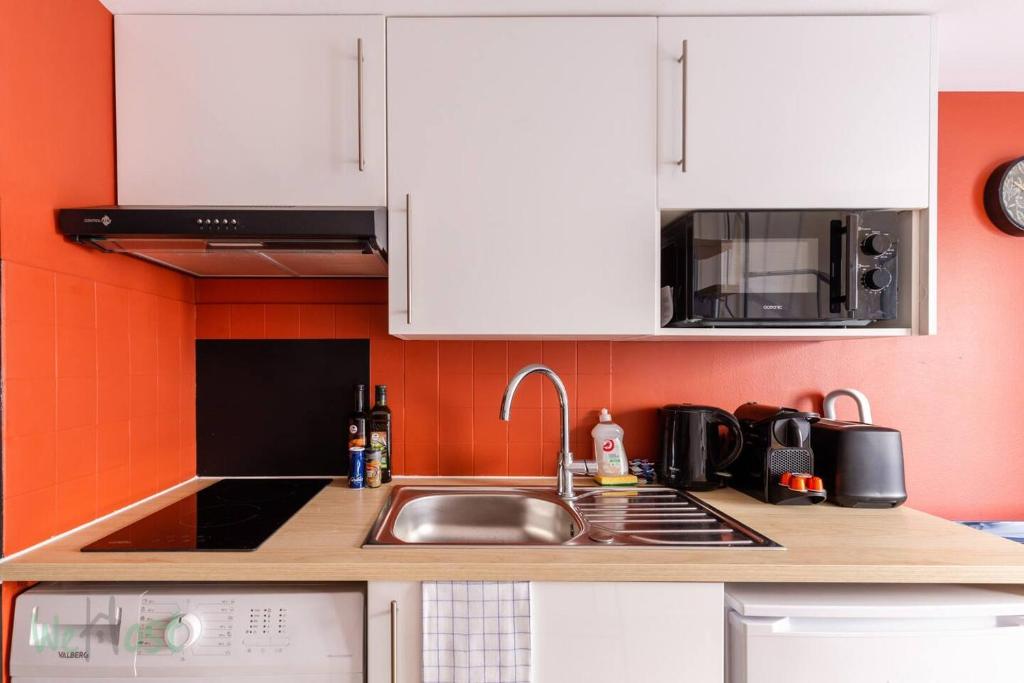 里昂Duplex-Université的厨房配有水槽和微波炉