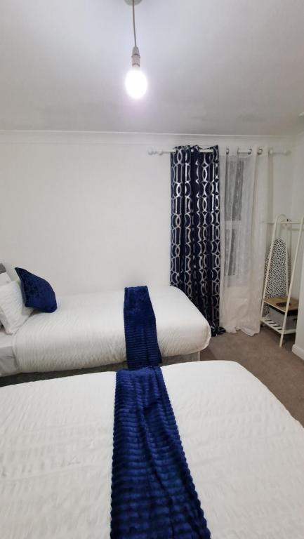 吉林汉姆Beautiful 2-Bed House in Gillingham的客房设有两张床和窗户。