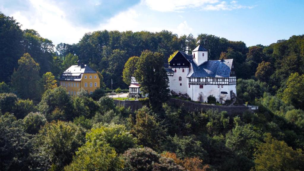 Kavaliershaus neben Schloss Rauenstein的森林中间的白色大房子