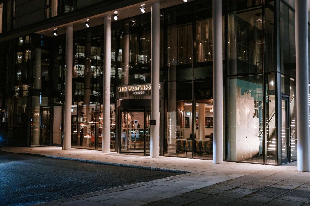 伦敦The Westminster London, Curio Collection by Hilton的夜间在建筑物前的商店