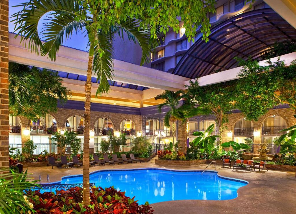 亚特兰大Courtland Grand Hotel, Trademark Collection by Wyndham的酒店大堂设有大型游泳池和棕榈树
