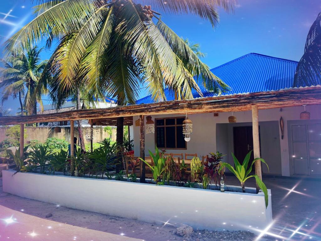 帕杰Villa Upendo Paje的前面有棕榈树的房子