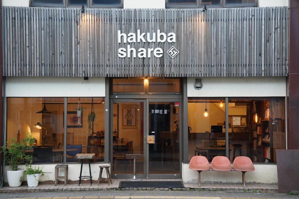 白马村白馬シェア Hakuba share的前面的商店,前面有两把椅子