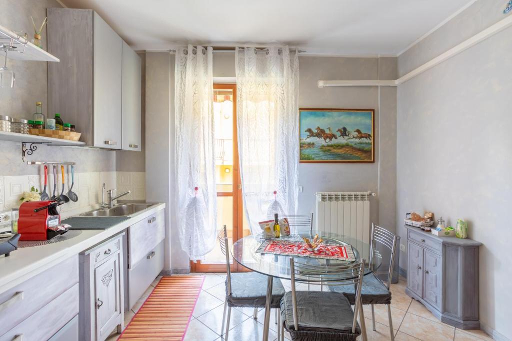 阿罗纳Ca di PA' Apartment的厨房配有玻璃桌