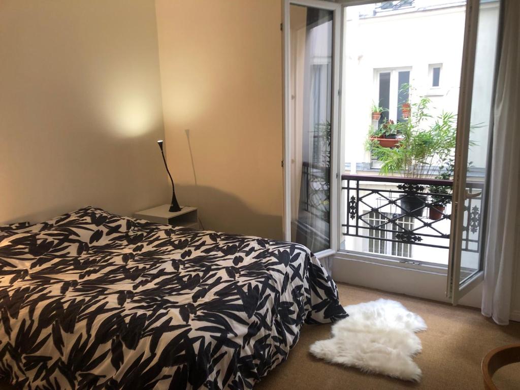巴黎Chez Vero et Bruno的卧室设有黑白床和窗户。