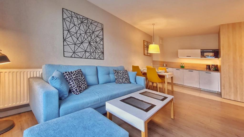 米兹多洛杰HOLIDAY HOME Bel Mare 308c的客厅配有蓝色的沙发和桌子