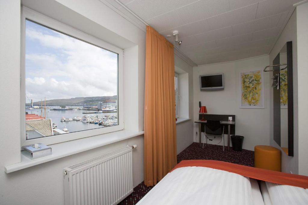 托尔斯港托斯翰酒店的一间卧室设有窗户,享有海港景色