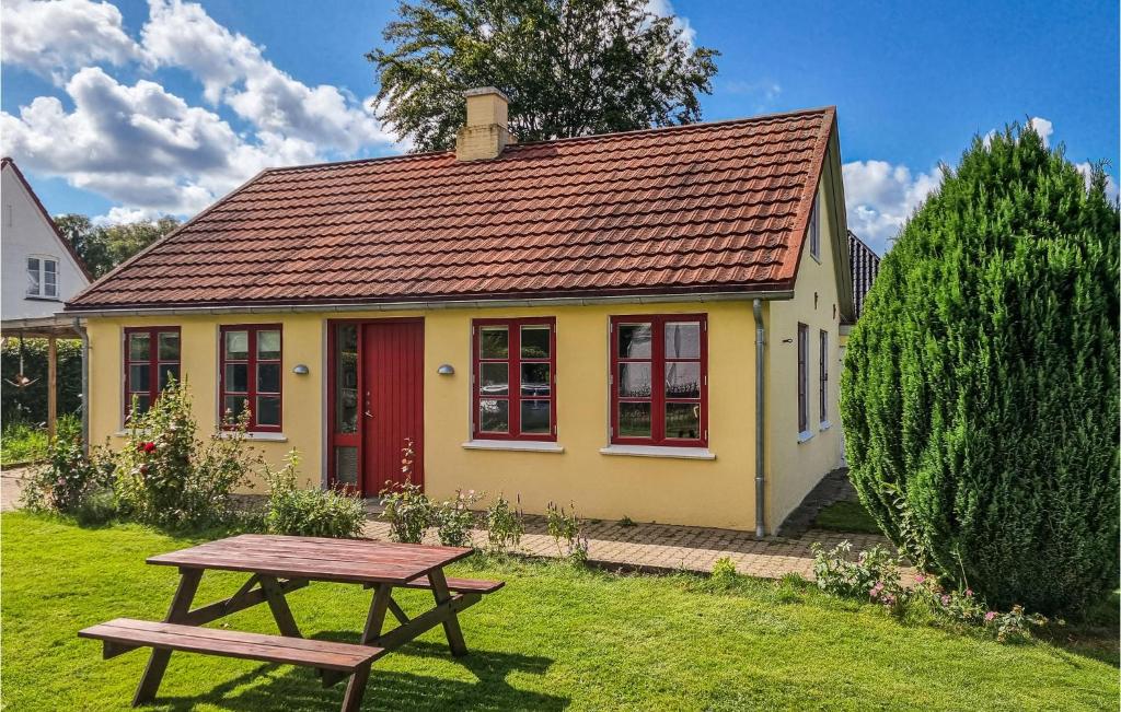 奥本罗Lovely Home In Aabenraa With Kitchen的黄色的房子,有红色的门和野餐桌
