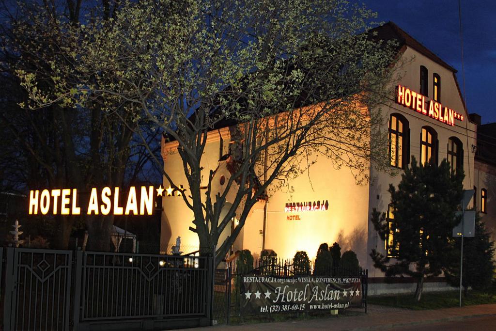 塔尔诺夫斯凯古雷Hotel Aslan的一间在晚上有灯光的酒店亚洲建筑