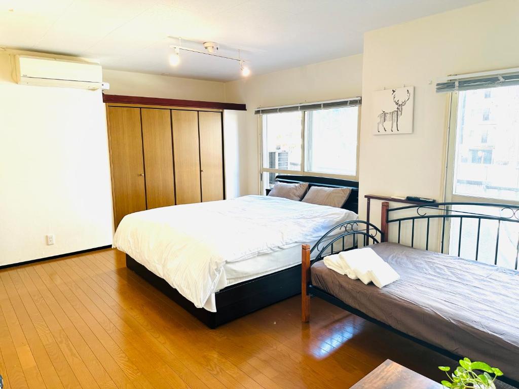 东京平和岛民宿的一间卧室设有两张床和窗户。