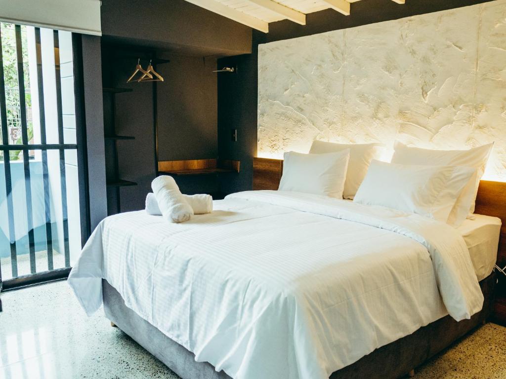 麦德林I Believe- All Suite Manila-Poblado的一间卧室配有一张带白色床单的大床