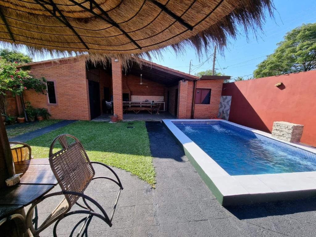 LuqueHospedaje Confortable en Luque的一个带游泳池和房子的后院