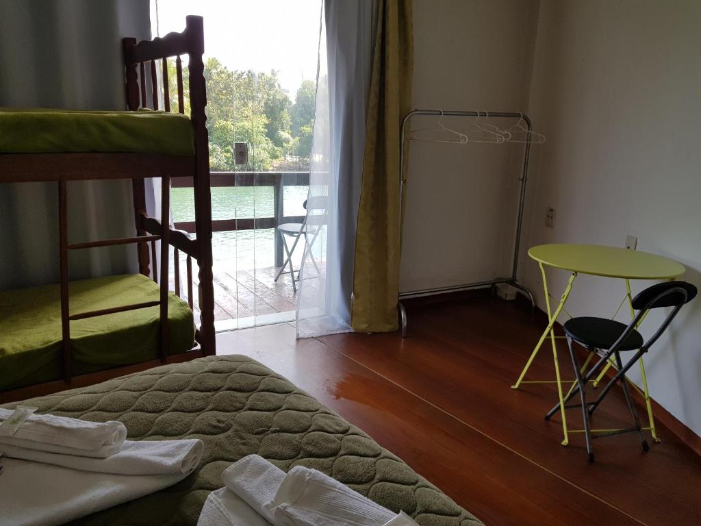 里约热内卢迈阿密旅馆的一间卧室配有一张床、一张桌子和一个窗户。