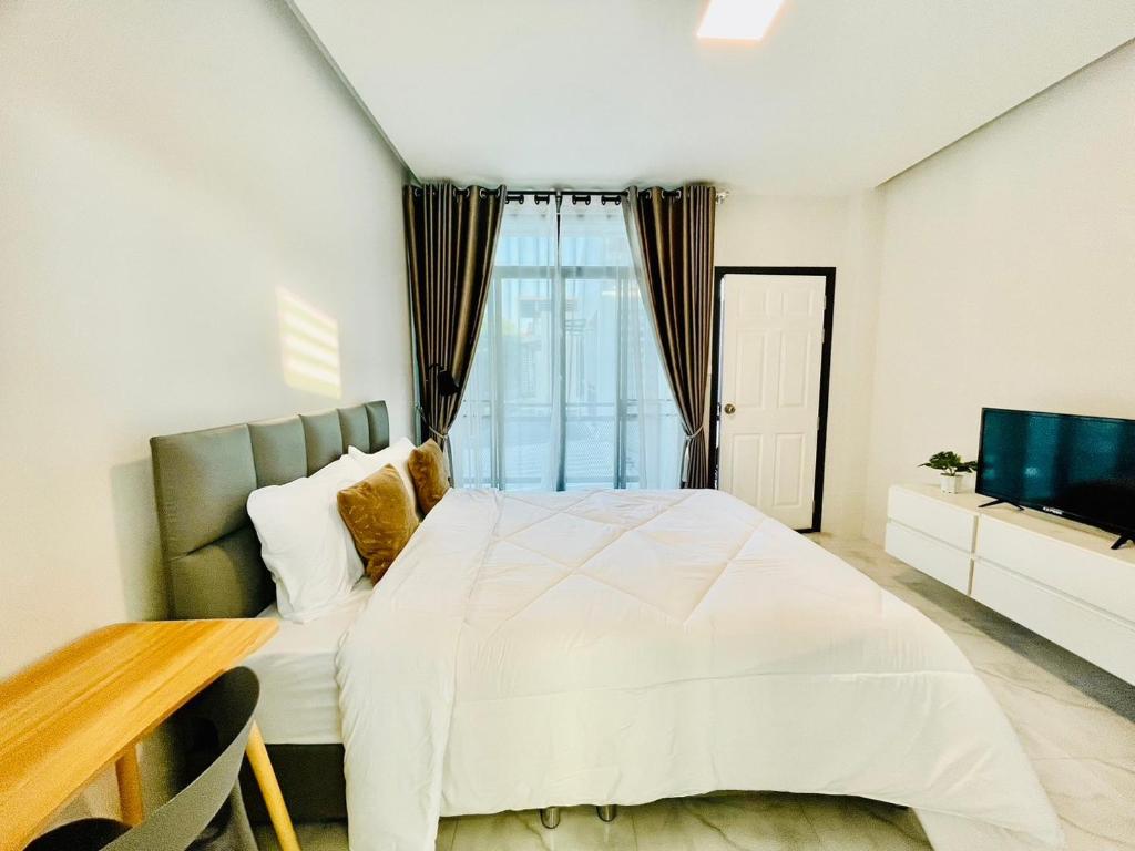 清迈Sky View Home and Hostel Chiangmai的卧室配有白色的床和电视。