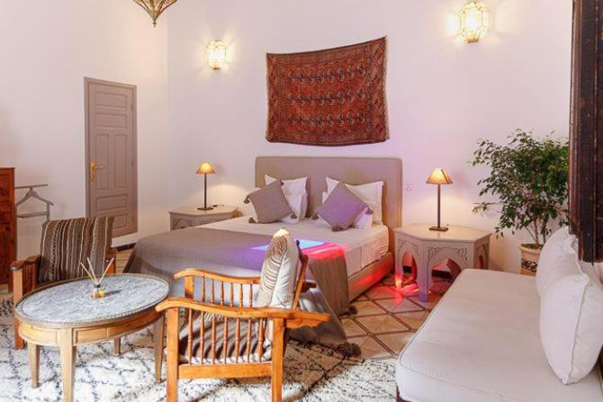马拉喀什Riad Zouhour的一间卧室配有一张床、一张桌子和一张沙发
