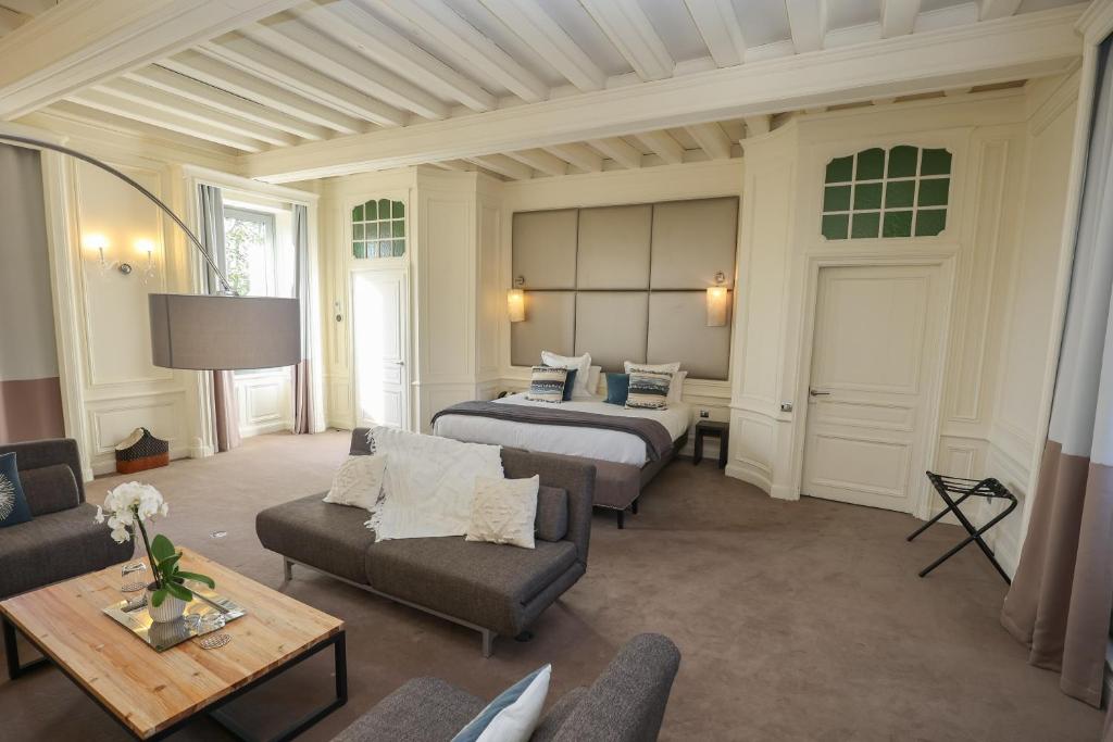 布里夫拉盖亚尔德Hôtel Château de Lacan的酒店客房,设有两张床和一张沙发