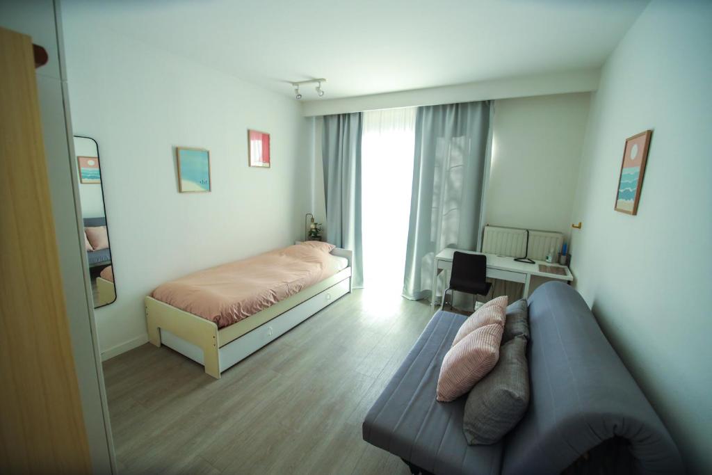 安特卫普Privé kamer met chill room en gedeelde badkamer - rand Antwerpen - afrit E313 Wommelgem - vlakbij tramhalte lijn 9 en 24的客厅配有沙发和1张床