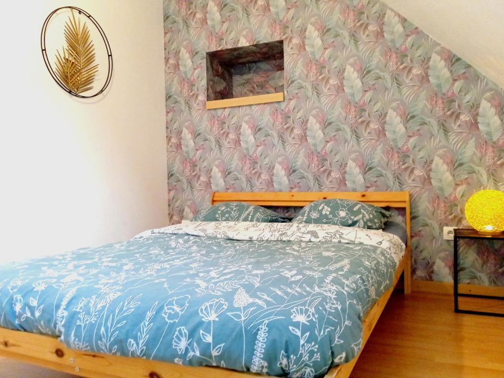 塞纳河畔罗米伊Élégante maison centre Romilly的一间卧室配有一张带花卉壁纸的床