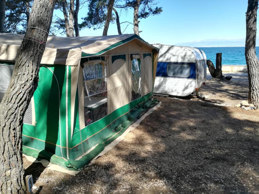 乌格连Room in Cabin - Caravan near the sea 1的水边的树上绿色的白色帐篷