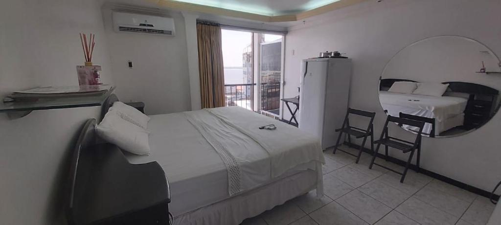 马瑙斯Riverfront Retreat Prime Location Apartment with Stunning Views of the RioNegro的一间卧室配有一张床、镜子和一张桌子