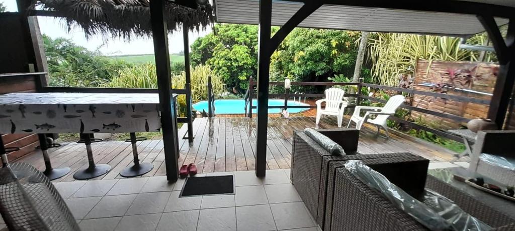 勒弗朗索瓦Le Chalet Tropical的一个带桌椅的庭院和一个游泳池