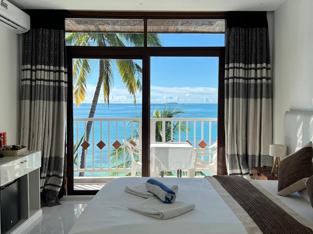 迪弗西Heron Beach Hotel - The Best Maldivian Getaway in Dhiffushi,Maldives的一间卧室配有一张床,享有海景