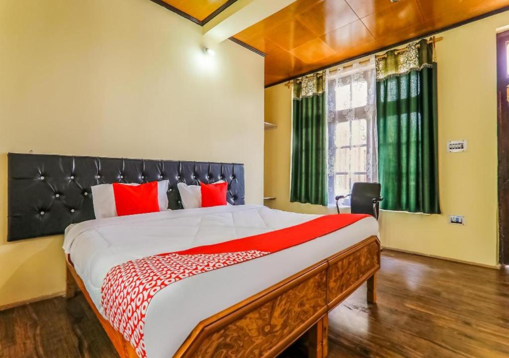 列城Guest House Naazh的一间卧室配有一张带红色枕头的大床