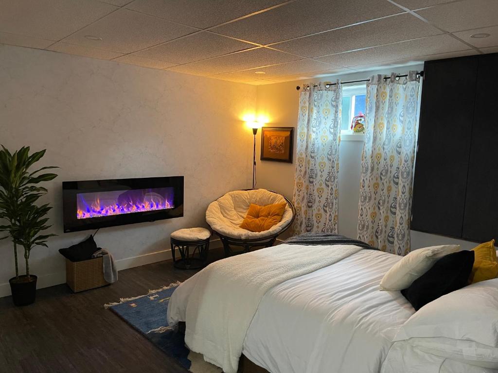 Ange-GardienSuite au centre de l’Estrie的卧室配有一张床,墙上配有电视。