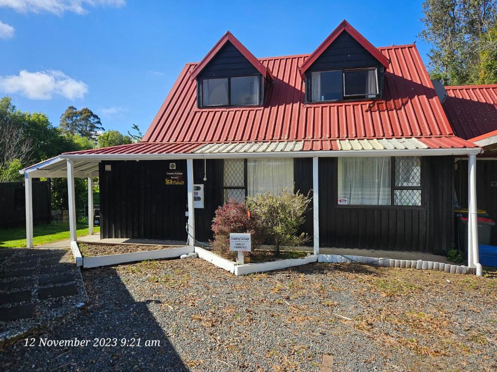 WhakatahuriCountry Cottage Rotorua的红色屋顶的房子