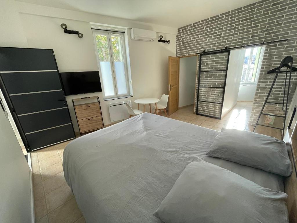 卡代纳Studio hypercentre Cadenet的一间卧室设有一张大床和砖墙