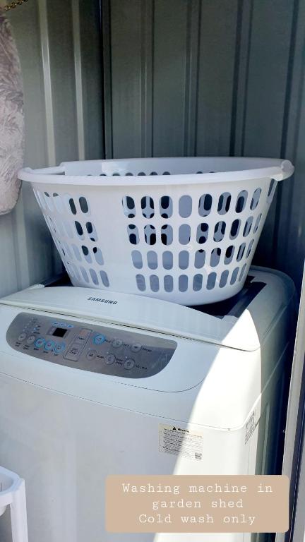 罗托鲁瓦Rotoruas Tiny Gem Guest House with SPA的洗衣机上的一个洗衣篮