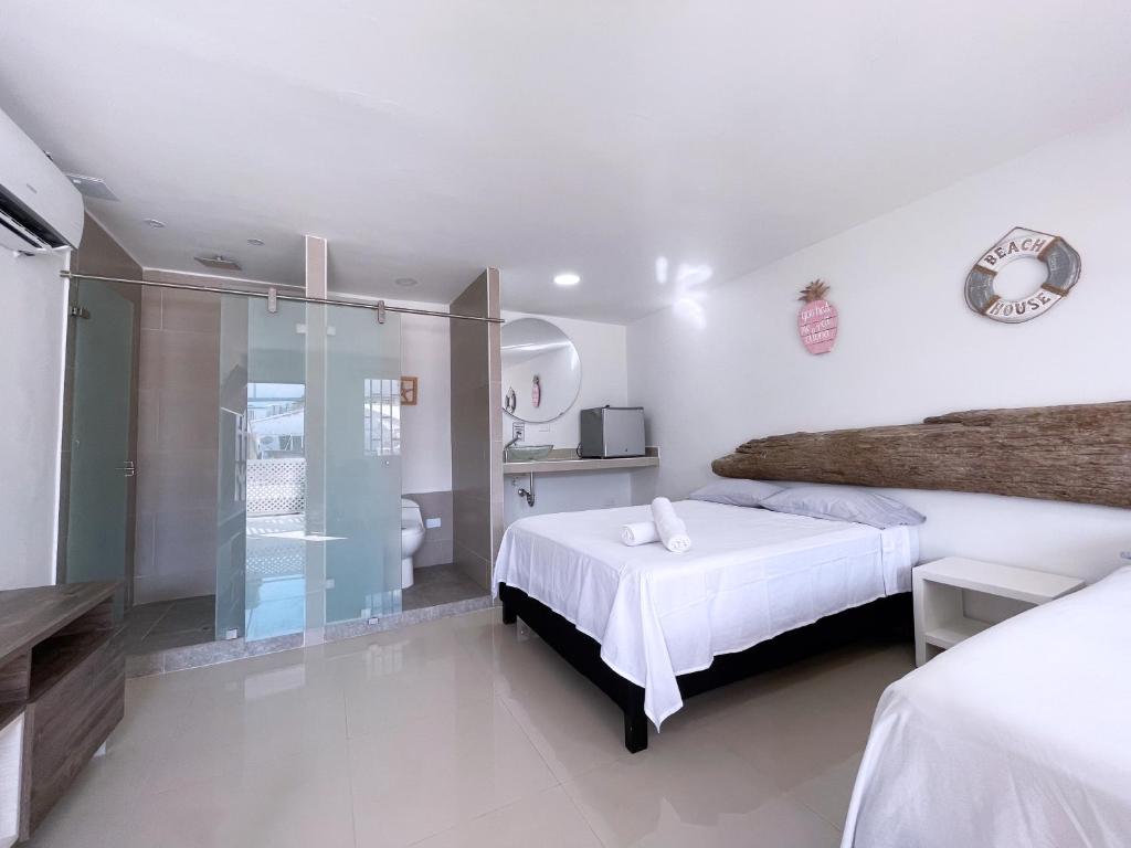 圣安德烈斯Island Vibes的白色卧室配有一张床和淋浴