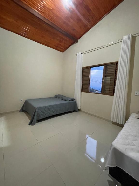 圣托梅-达斯莱特拉斯Casa Por do Sol.的一间卧室设有一张床和一个窗口