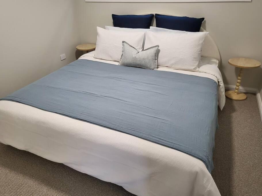 麦夸里港Coastal Pod的一张配有蓝色和白色床单及枕头的大床