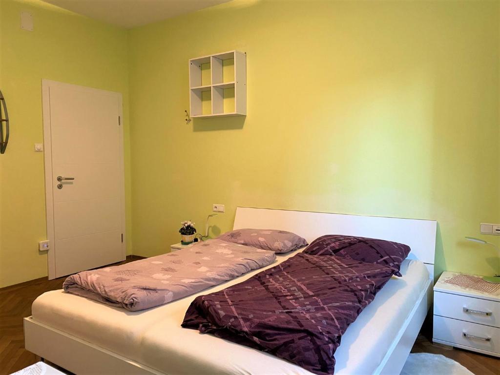 博尔扎诺Bozen Mitte的一张小床,位于带绿色墙壁的房间里