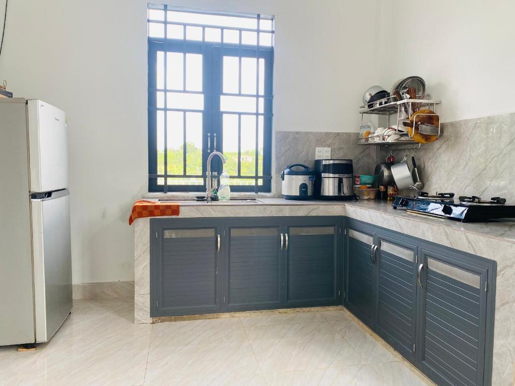 保禄Homestay Nhà Của Gạo的厨房配有蓝色橱柜和水槽