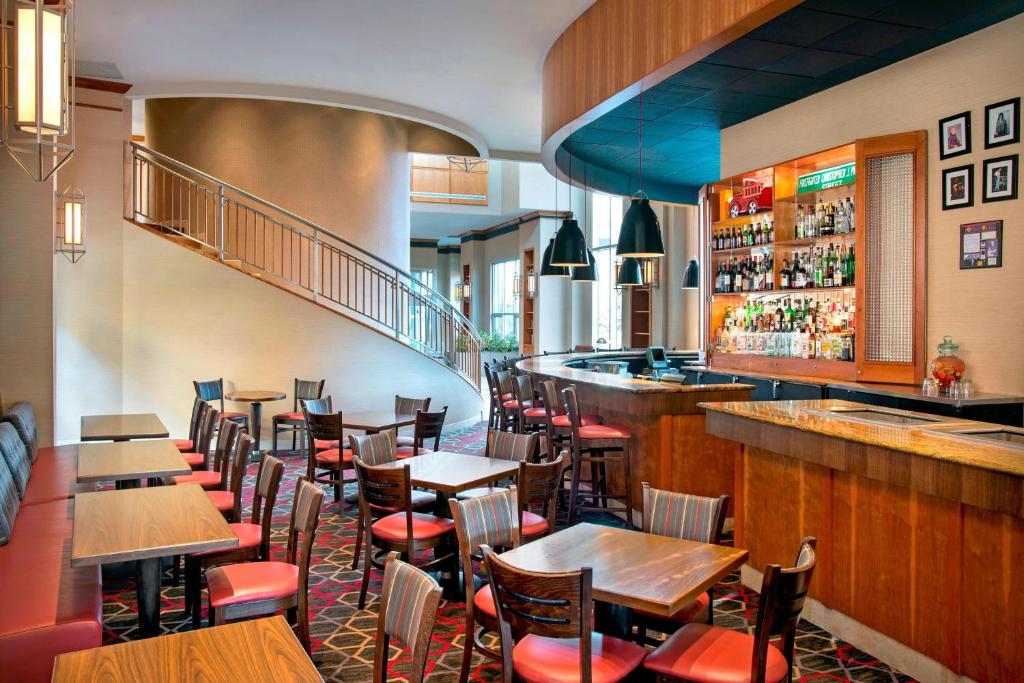 普莱恩维尤福朋喜来登梅尔维尔长岛酒店的一间带桌椅的餐厅和一间酒吧