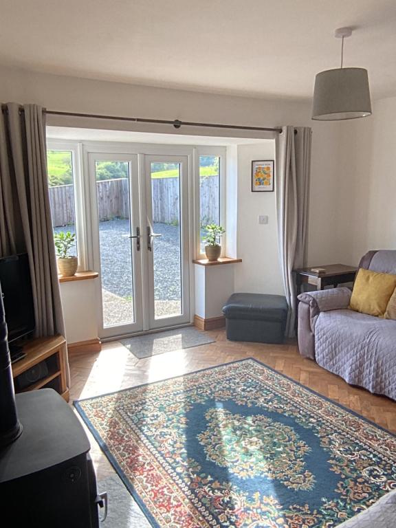 奥斯威斯3 Bedroom Bungalow in Llanrhaeadr Ym的带沙发和玻璃门的客厅