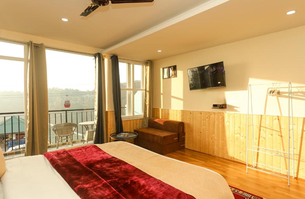 达兰萨拉Himalayan Suite的一间带大床的卧室和一个阳台