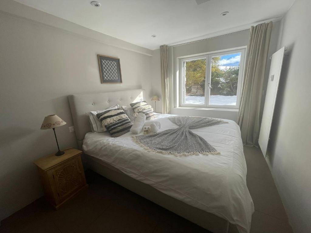 韦尔比耶Verbier Apt 2 rooms (3 guests)的卧室配有白色的床和窗户