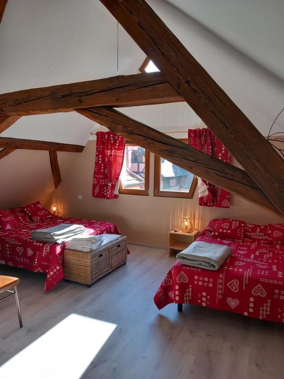 科尔马Gite Schlossberg的阁楼间 - 带2张床和红色床单